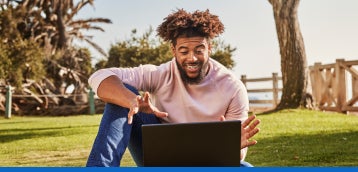 An individual using their laptop outside.