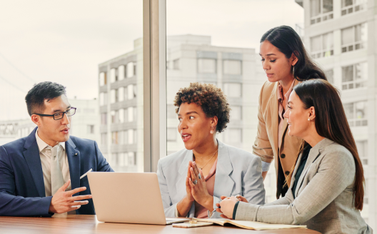 An individual working on their laptop inside.